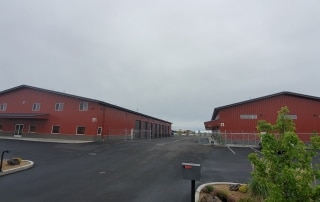 A pair of red commercial, steel buildings from RCI Construction